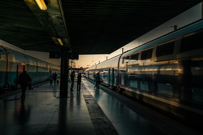 Quais de la gare Saint-Charles à Marseille avec trains à l’arrêt, voyageurs en silhouette et perspective ferroviaire