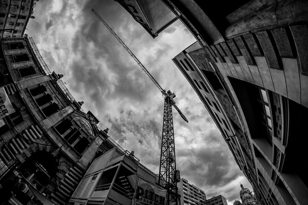 Grue de chantier entre des immeubles près de la Cathédrale de la Major à Marseille, sous un ciel nuageux.