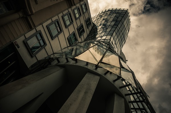 Maison dansante à Prague vue en contre-plongée, avec sa tour de verre, sa façade historique