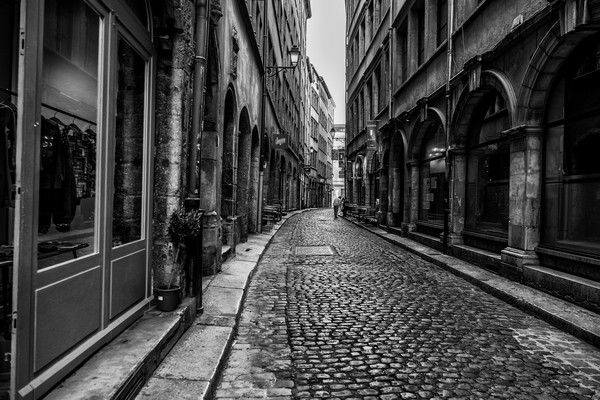 Rue pavée du Vieux Lyon façades anciennes et d’arches en pierre quartier Saint-Jean