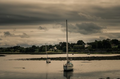 Voiliers dans le port de Kinvara sous un ciel chargé, comté de Galway en Irlande