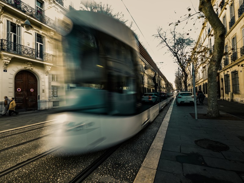 Tramway de Marseille en mouvement sur le boulevard Longchamp avec façades anciennes et rails